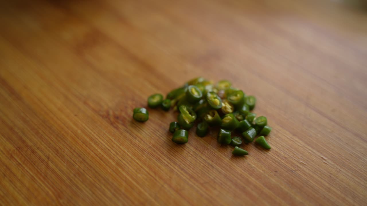 Chopped spicy, green chilies on chopping board. Pile of chilies.