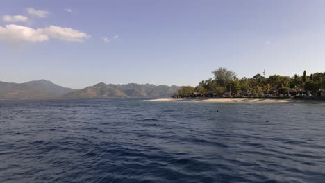 Aerial-flyover-beautiful-indian-ocean-with-anchored-ships-and-empty-beach-on-Gili-Air