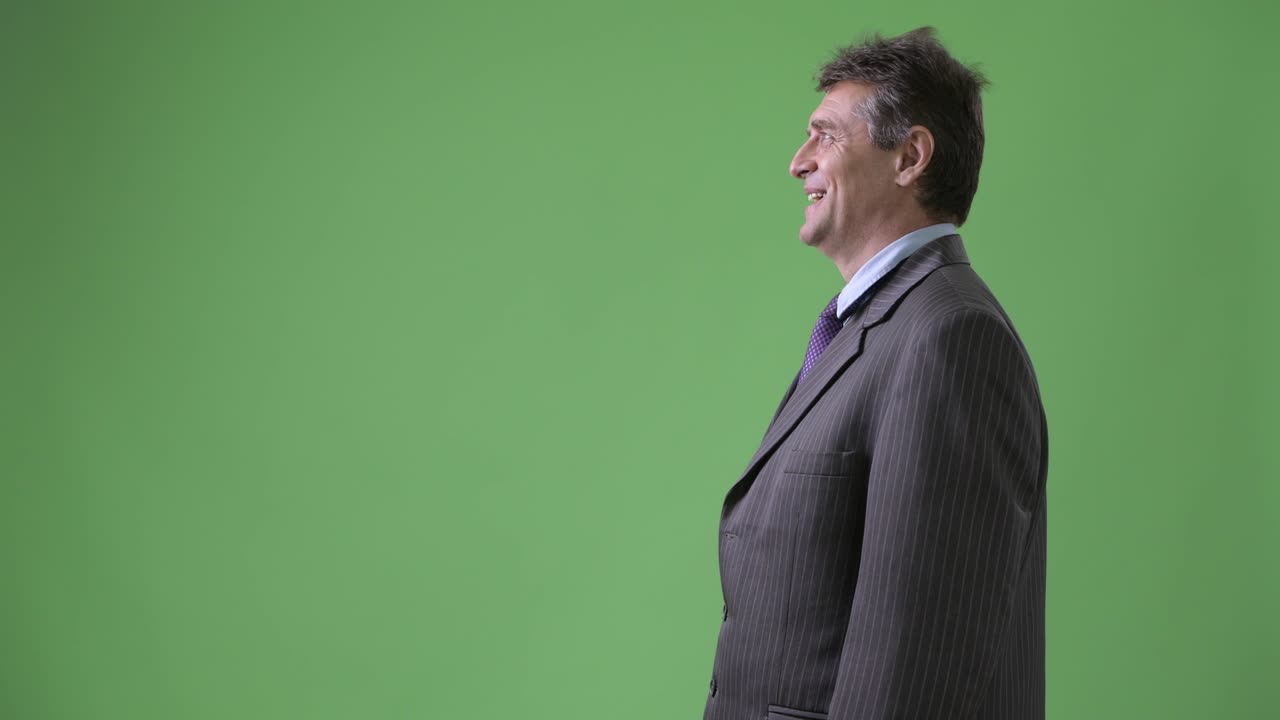 hombre de negocios maduro y guapo contra un fondo verde