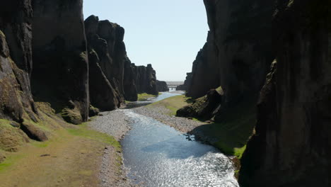 Vista-Aérea-Del-Río-Fjadra-Que-Fluye-En-El-Profundo-Cañón-Fjadrargljufur-En-El-Sur-De-Islandia.-Destino-De-Viaje.-Drone-Volando-En-La-Grieta-Cubierta-De-Musgo-Rocoso-Del-Desfiladero-Fjadrargljufur