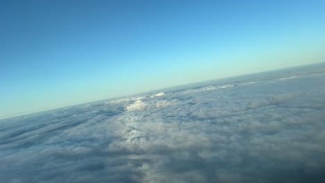 pov flying over a sea of clouds at the eyes of the pilots of an airplane early in the morning during a right turn