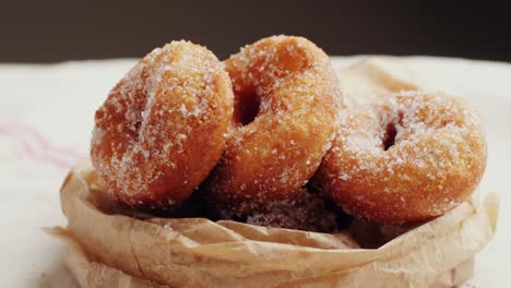 sugar-dusted donuts in brown paper