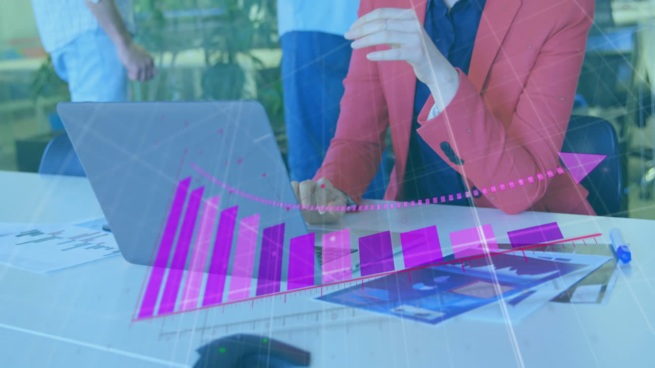 animación de gráfico sobre la sección media de una mujer de negocios caucásica trabajando en una computadora portátil en un escritorio en la oficina