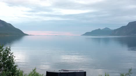 camping on a car roof tent near tranquil lake in sifjord camping grounds, norway