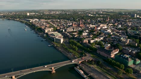 Mainz-Wide-shot-by-a-Drohne-getting-closer-to-town-down-midday-in-bright-daylight-showing-the-red-Dome-and-the-lovely-old-Bridge-on-the-Rhine-River