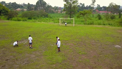 Estudiantes-Uniformados-Juegan-Al-Fútbol-En-Un-Campo-En-Tanzania,-África-Oriental