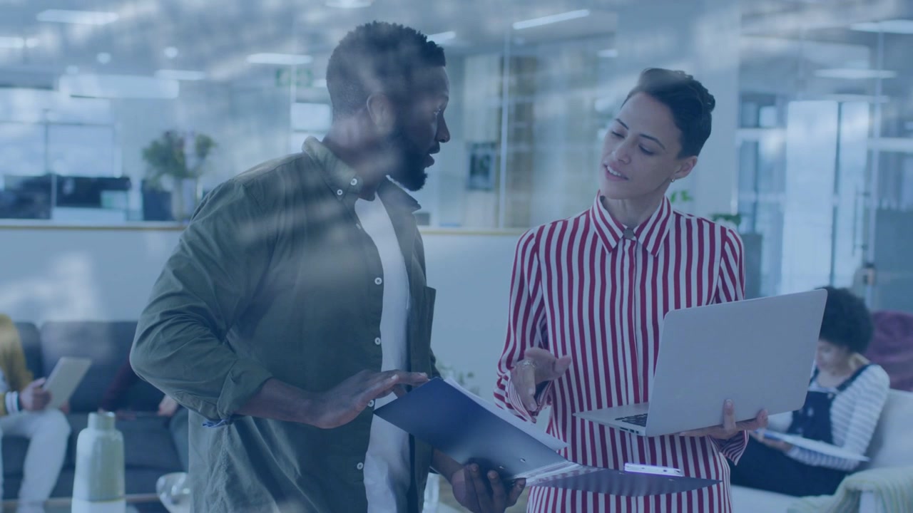 Man opening blue folder and woman holding laptop, pair reviewing papers and marking for business