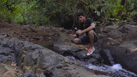 Niño-Adolescente-Indio-Llenando-Agua-Del-Río-Natural-Río-Seco-En-La-Selva-India-En-Pantalones-Cortos