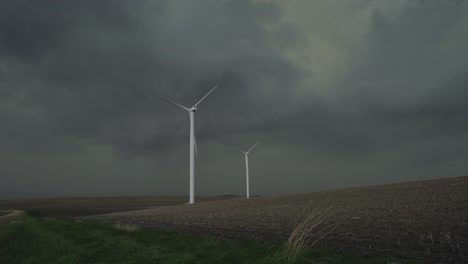 wind turbines rise against a looming storm, harnessing energy as dark clouds gather - medium shot