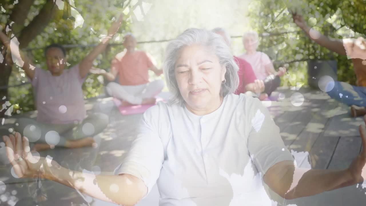 Animation von Lichtflecken und Bäumen über verschiedenen älteren Menschen, die Yoga im Garten praktizieren