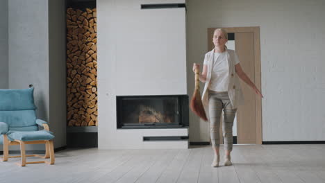 woman cleaning her living room with a broom