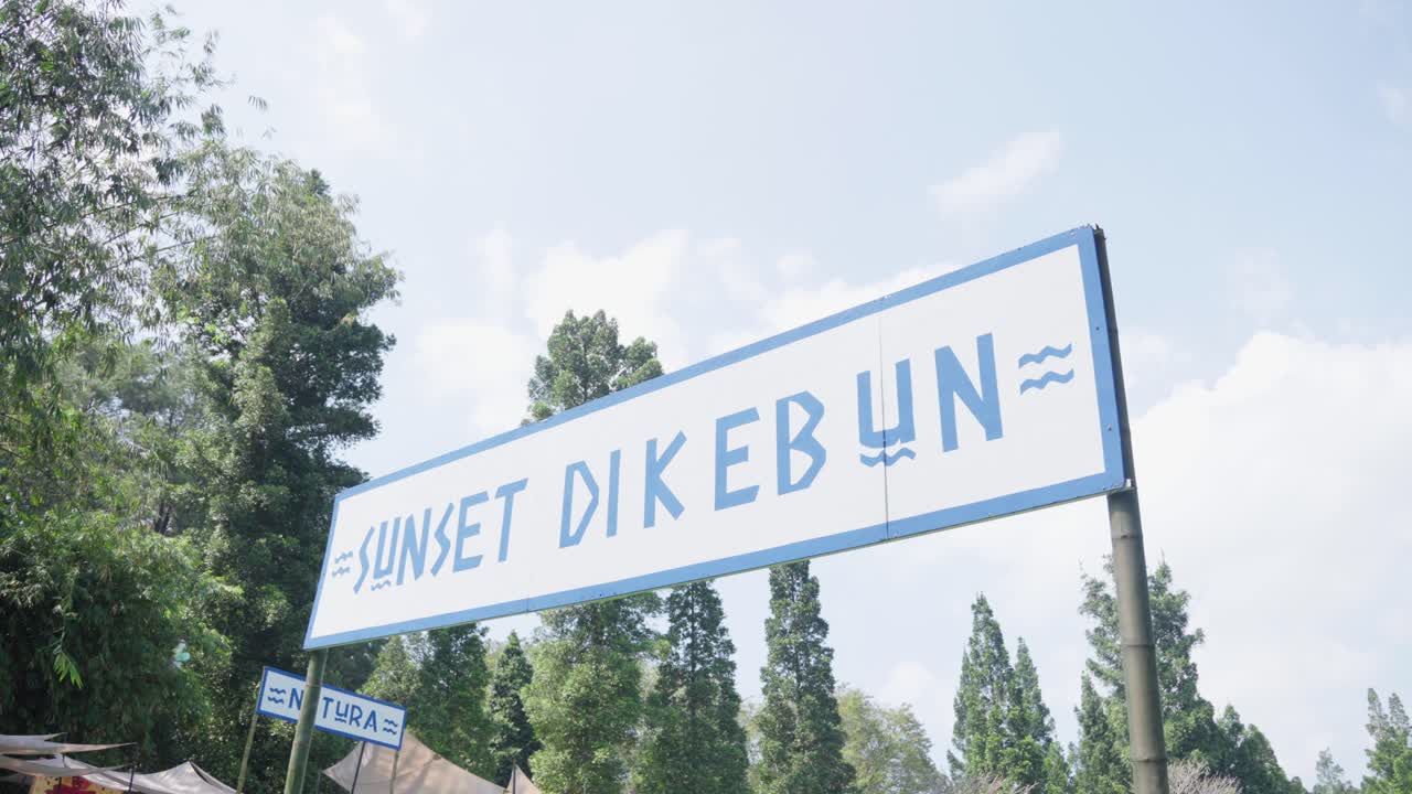 Entrance sign to an outdoor concert at Kebun Raya Bogor under clear skies during the day