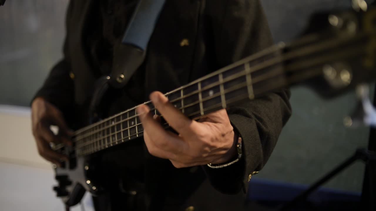 Membro della band che suona la chitarra, inquadratura frontale.