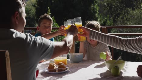 Family-eating-breakfast-together-outdoors