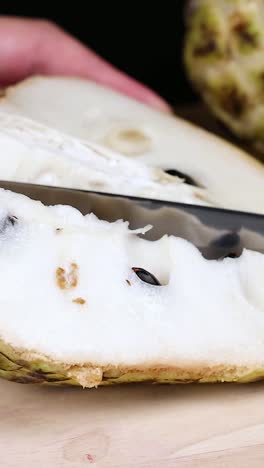 slicing a custard apple to reveal its seeds