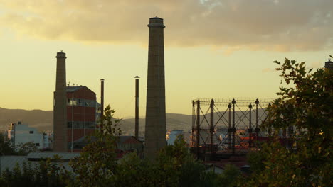 Industrial-chimneys-and-gasometer-at-sunset.-Greece,-Athens
