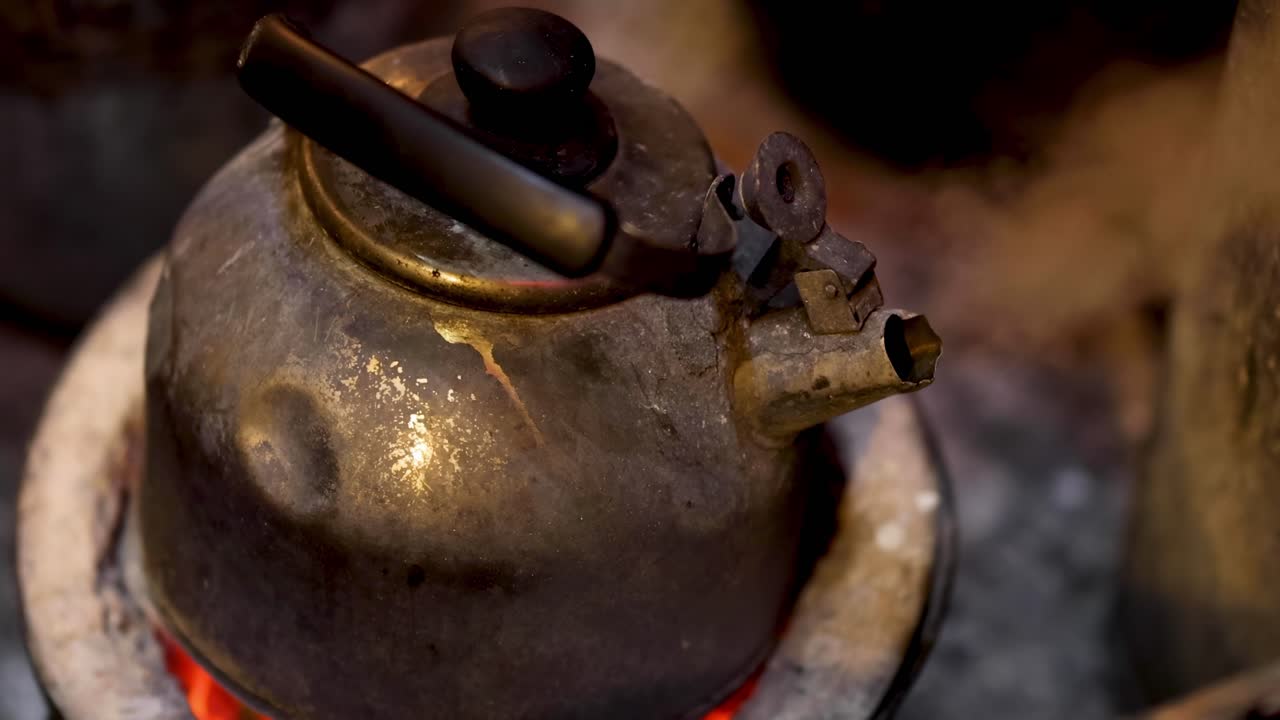 빛나는 석탄 스토브에서 증기가 나는 오래된 케이틀