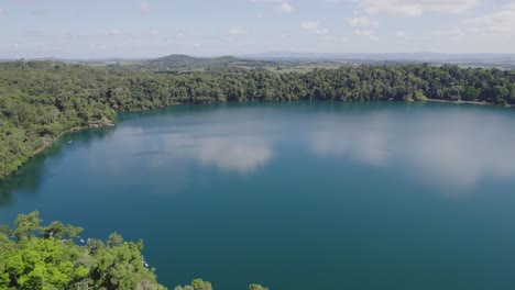 Reflejo-Del-Cielo-En-Las-Tranquilas-Aguas-Del-Lago-Eacham-En-Queensland,-Australia---Toma-Aérea-De-Drones