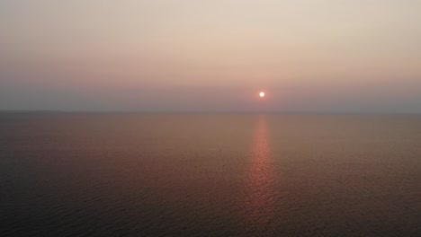 위스콘신주 도어 카운티에 있는 엘리슨 블러프 주립 공원에서 시원한 여름 밤 멋진 일몰을 포착하는 두 소나무 사이를 지나가는 드론 샷