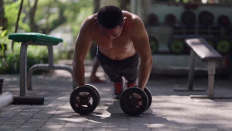man doing dumbbell exercise in an outdoor gym