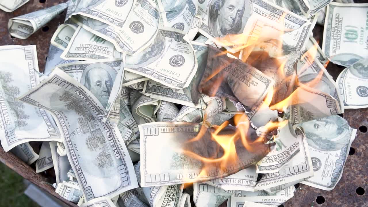 Counterfeit money burns slowly. Burning currency. Fake dollars