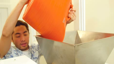 hombre empaquetando una bolsa de café de una máquina de sellado
