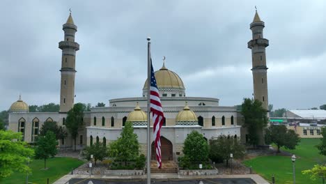 Aerial-approaching-shot-of-american-flag-in-front-of-Islamic-Center-of-America-in-Dearborn,-Michigan,-in-the-United-States