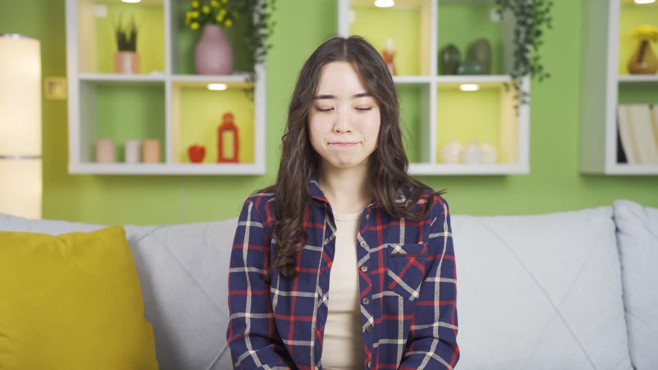 젊은 아시아 여성이 부정적인 제스처로 카메라를 쳐다보고 있습니다.