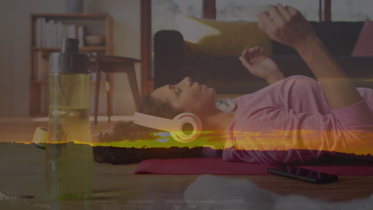 animación del paisaje del atardecer sobre una mujer biracial escuchando música con auriculares.