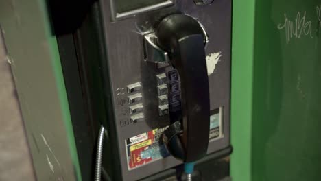 old green payphone box in downtown