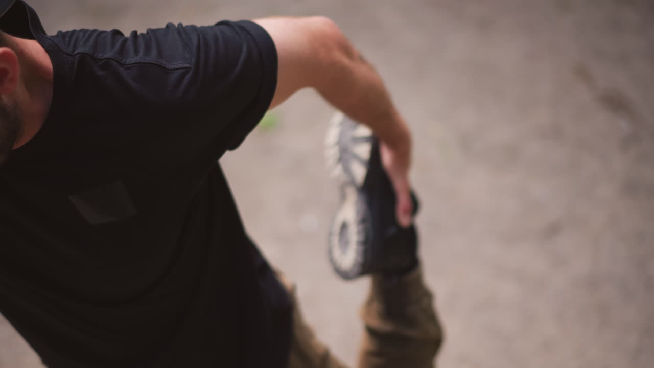Man Stretching His Leg Before Jog, Individual Performing Mobility Drills In Casual City Attire, Person In Comfortable Urban Outfit Engaging In Dynamic Stretches Prior To Running Session