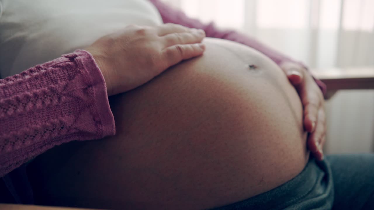 Donna incinta felice in attesa del bambino a casa