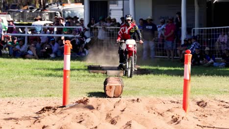 motorcyclist weaving through barrels in a race