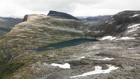 beautiful-mountain-landscape-with-a-light-snow-cover-and-a-lake,-norway,-europe,-drone