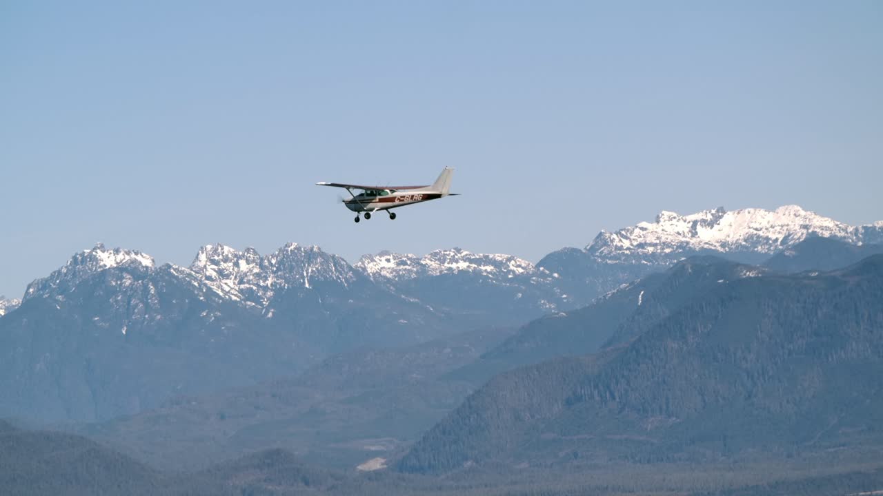 avión monomotor volando con montañas cubiertas de nieve como telón de fondo