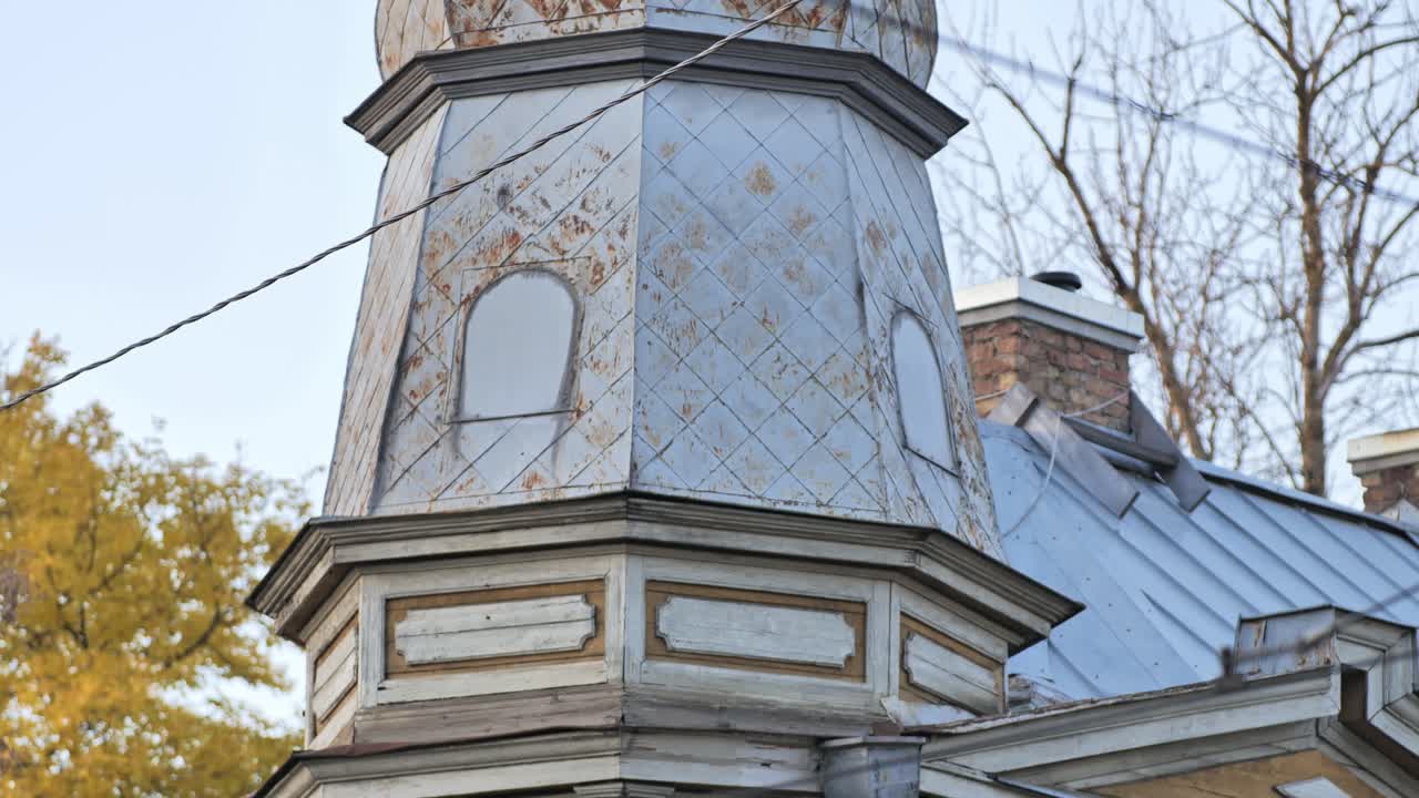 Close-up of Riga’s classic wooden facade with bay windows and autumn trees