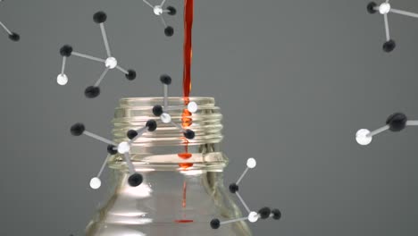 red liquid on bottle and molecule models