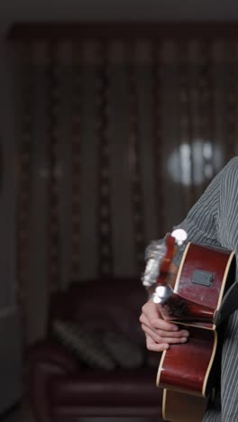 man singing and playing acoustic guitar into a microphone