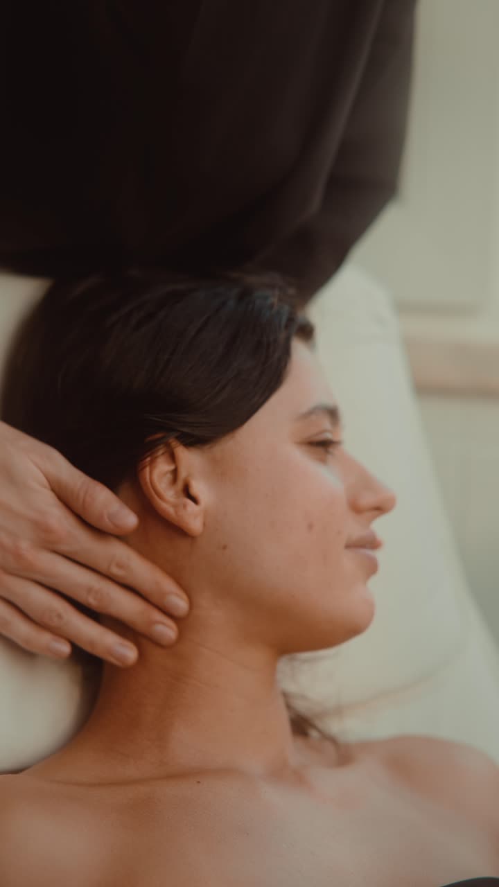 Ung kvinde, der får afslappende nakke- og skuldermassage