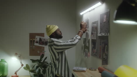 man working on a mood board in a creative office space