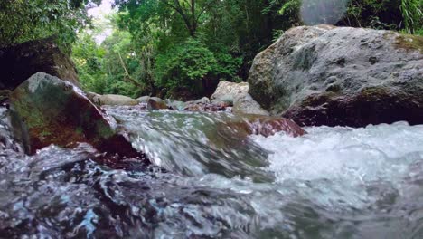 Cinematic-shot-of-creek-flowing-between-rocks,-Jima-river-in-Dominican-Republic