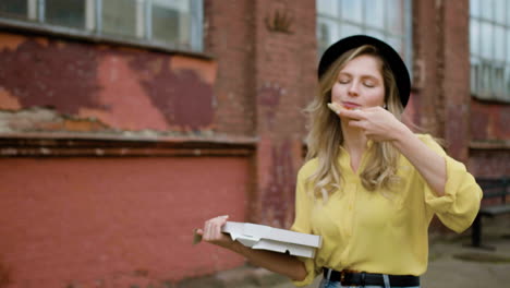 blonde girl eating on the streets