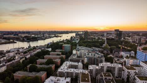 el horario de la puesta de sol en hamburgo, alemania, con el tráfico de barcos en el río norderelbe