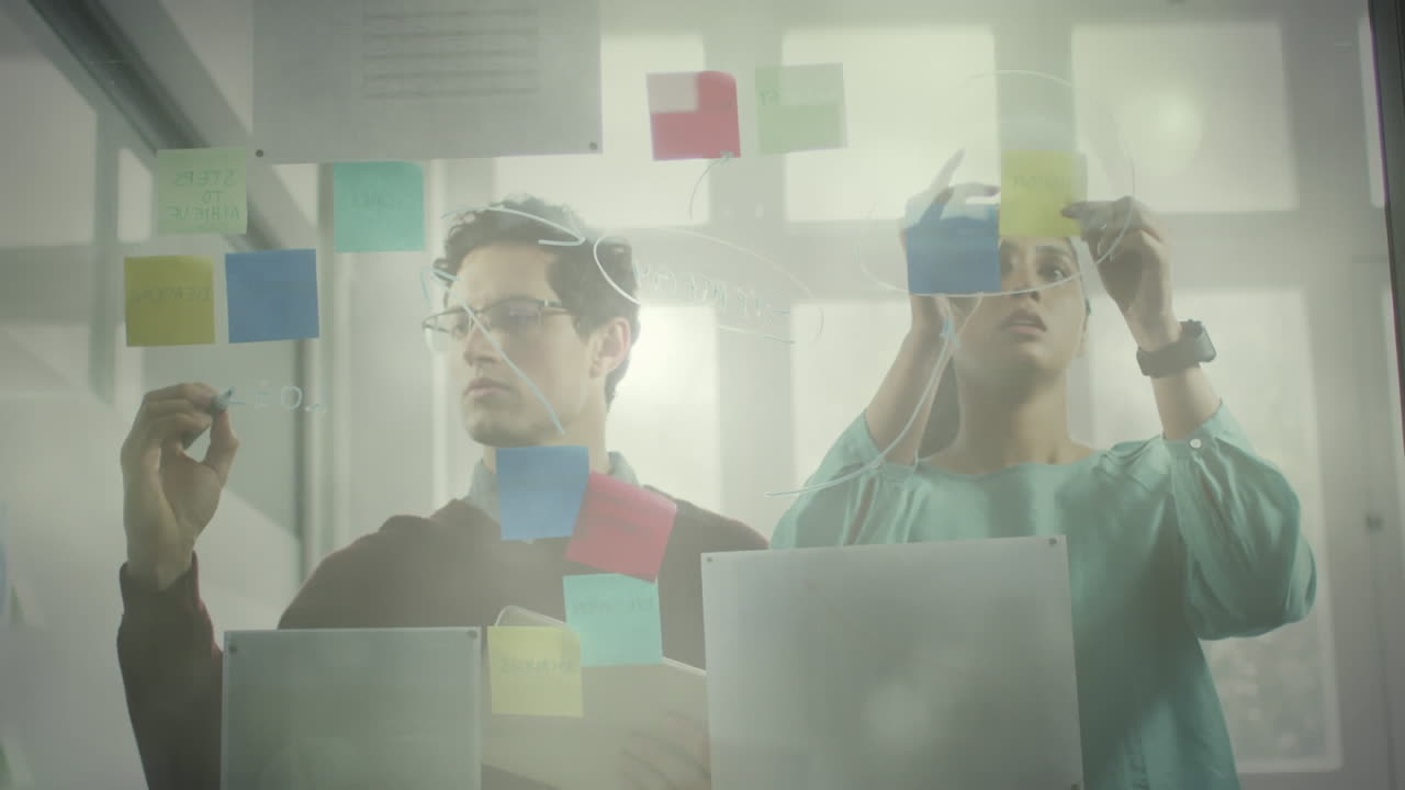 puntos de luz contra diversos colegas de oficina escribiendo en tablero de vidrio en la oficina