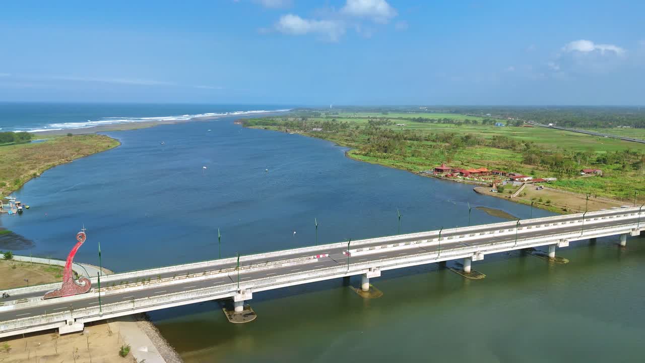 Aerial View of a Bridge Over a River Leading to the Ocean