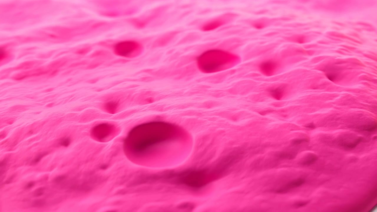 Hava Kabarcıkları ve Hafif Dalgalanmalarla Pürüzsüz Parlak Yüzeye Yayılmış Parlak Pembe Slime Dokusu, Yakın Çekim