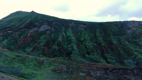 drone-pulls-away-from-majestic-mountain-to-reveal-island-highway-on-a-cliff