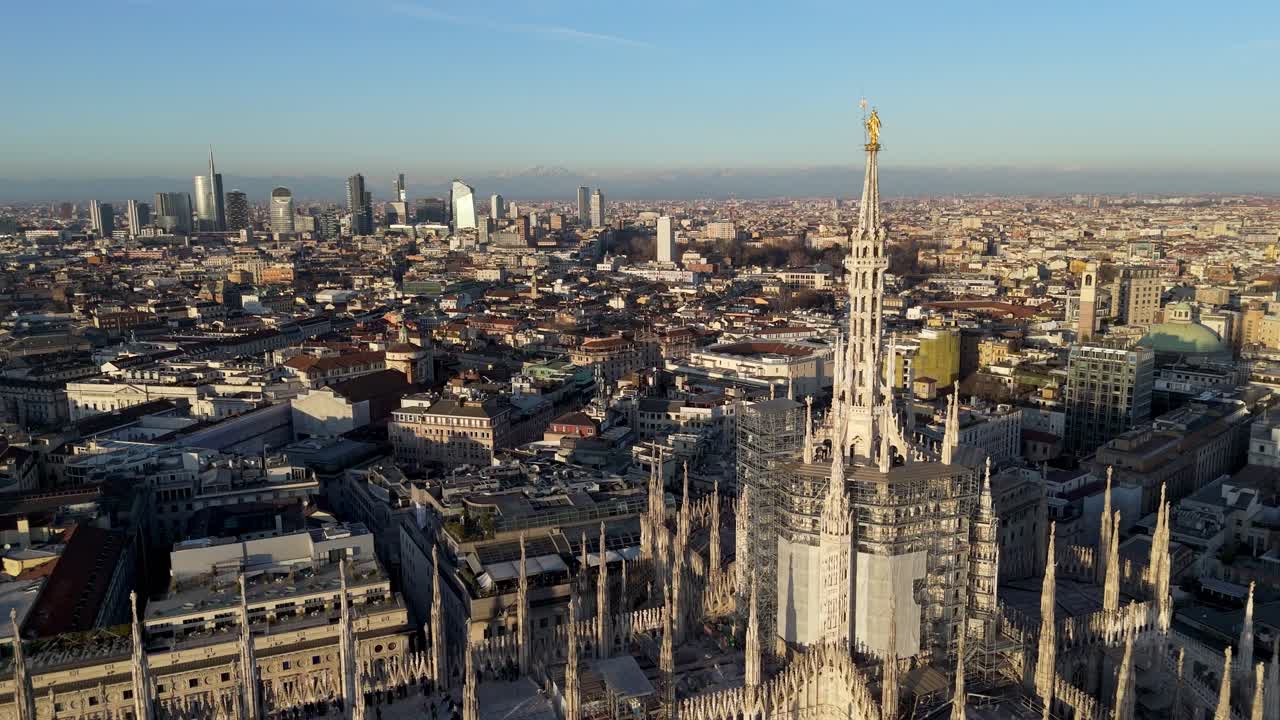 drone rotate around Milan duomo old cathedral revealing modern smart city with skyscraper building at distance during sunset
