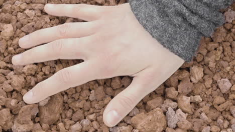 Nahaufnahme-Der-Hand-Einer-Frau,-Die-Vulkanischen-Kies-Sinnlich-Berührt