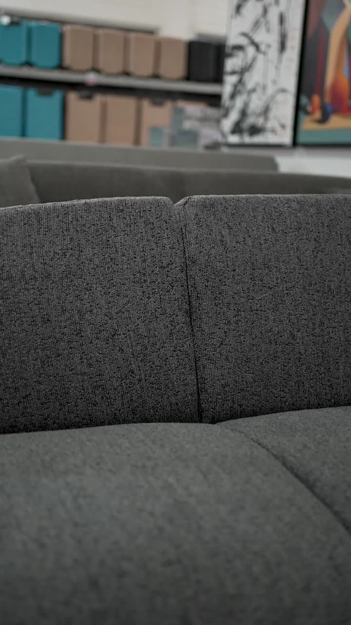 A detailed look at a modern living area showcasing a comfortable gray sofa, minimalist design, and aesthetic decor elements that enhance the ambiance of the space